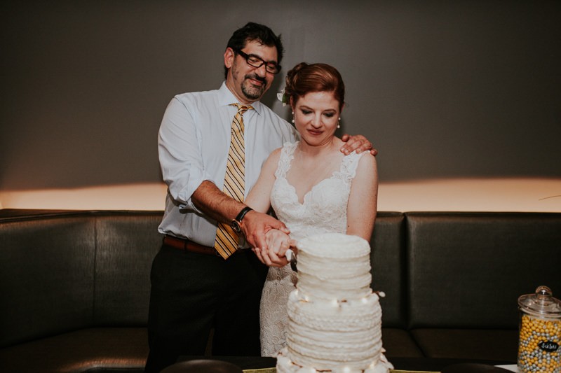 Bride and groom cut their three tier ruffled cake. 