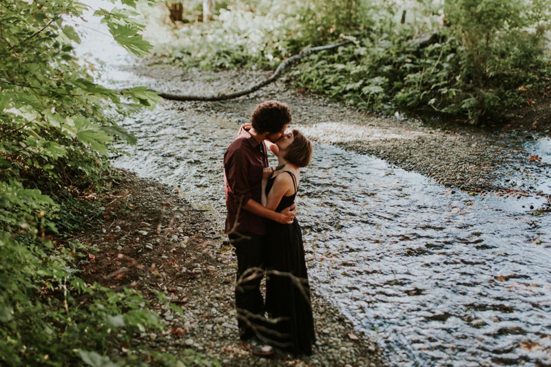Modern couple kissing near a creek, in Union, WA. 