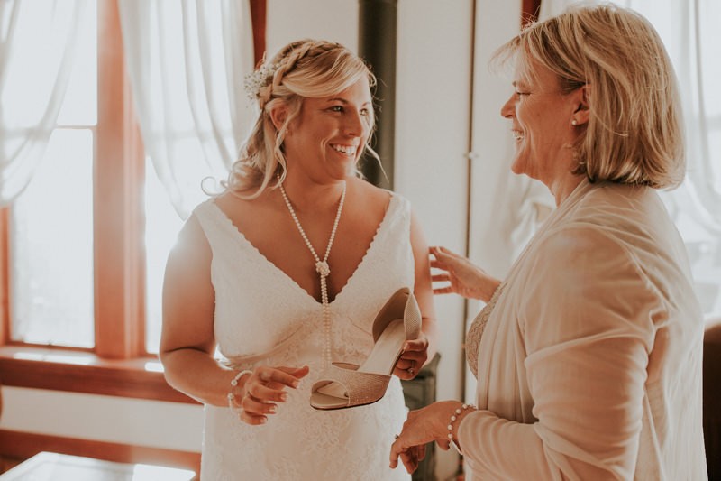 Winter bride wearing a lace v-neck dress, with a sweet braided half up-do and Baby's Breath.