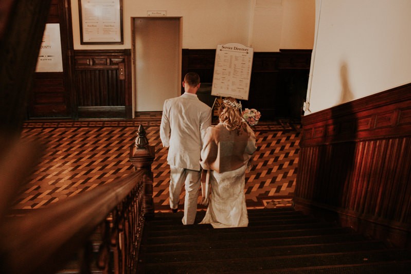 Historic courthouse wedding, with bride in a lace dress and groom in a light suit. 