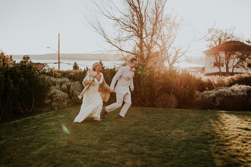 Barefoot bride running with her groom, in Port Townsend, WA. 