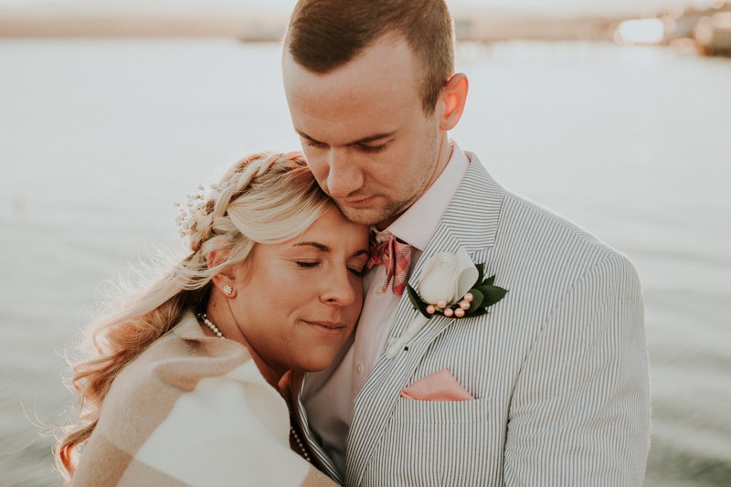 Romantic wedding details, with groom in a seersucker suit, rose boutonniere, pocket square and bow tie. 