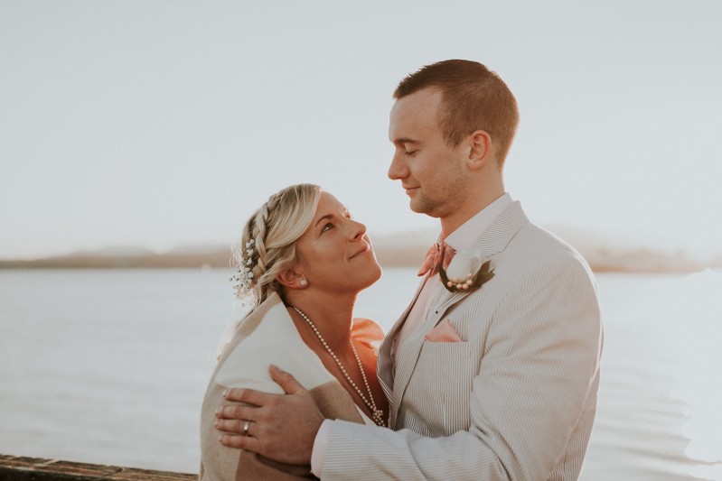 Adventurous Port Townsend elopement, with bride and groom hugging on the waterfront at sunset. 