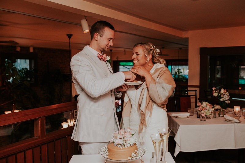 Cake cutting moment, with groom in a blue seersucker suit. 