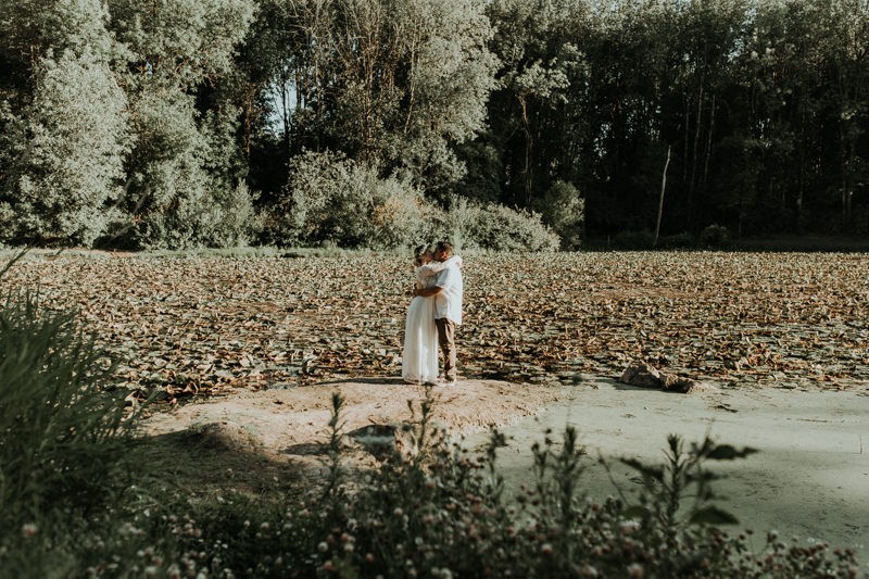 Summer elopement near Portland, OR, with bride and groom hugging by a pond. 
