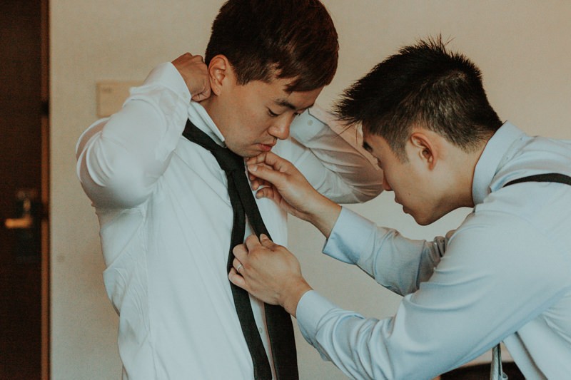 Groom getting ready with collared shirt and skinny tie. 