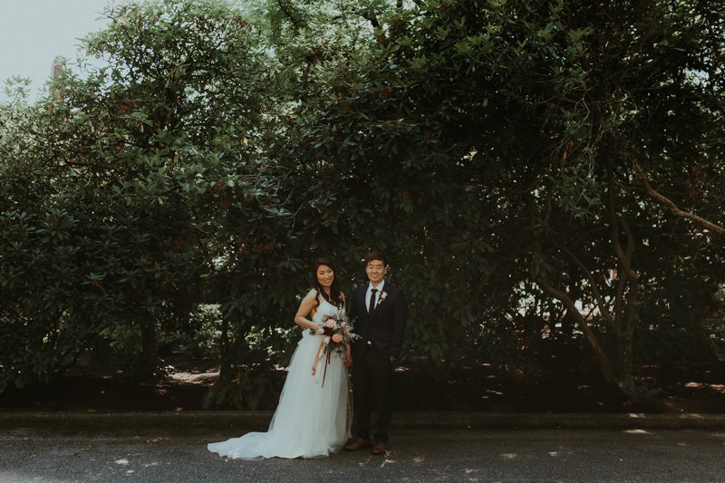 Dreamy garden wedding, with bride in floor-length tulle skirt and groom in navy suit. 