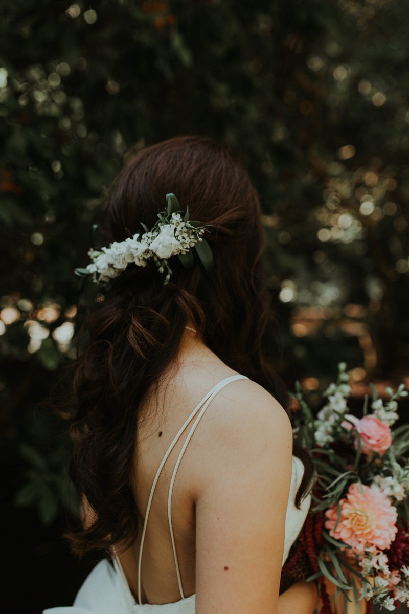 Garden bride with half updo and fresh floral hairpiece. 
