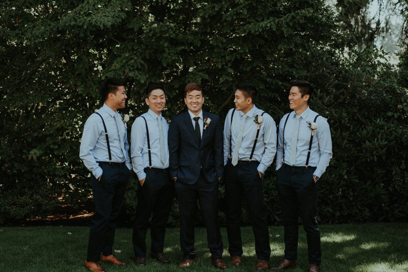 Modern groom and groomsmen in blue, with suspenders and Rose boutonnieres. 