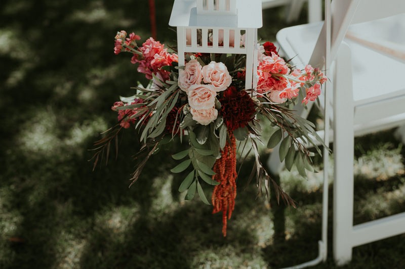 Pretty garden wedding florals, with soft pink Roses and red Hanging Amaranthus flowers in white lanterns. 