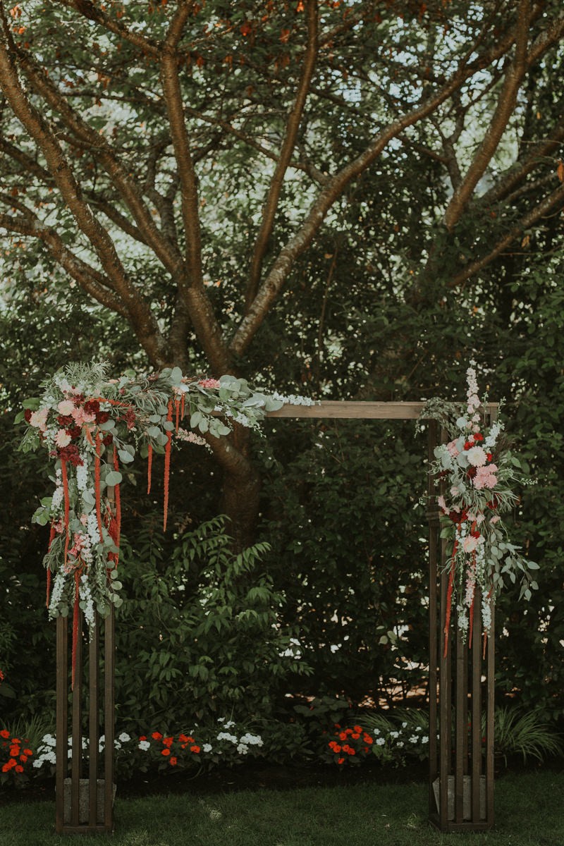 Gorgeous ceremony arch details, with fresh Eucalyptus leaves, hanging Amaranthus, Roses and dahlias. 