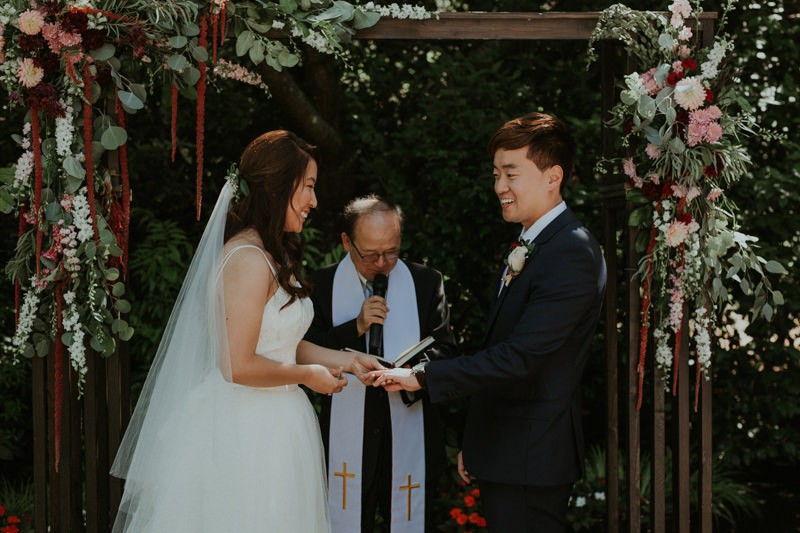 Seattle wedding ceremony with wooden altar arch and lush floral details. 