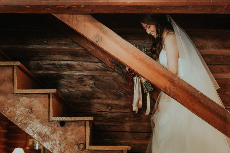 Robinswood House bride on a staircase, with long veil and tulle skirt. 