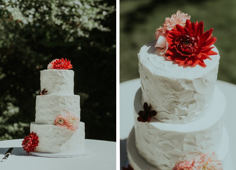 Classic white three tier cake with buttercream frosting and bright fresh flowers. 