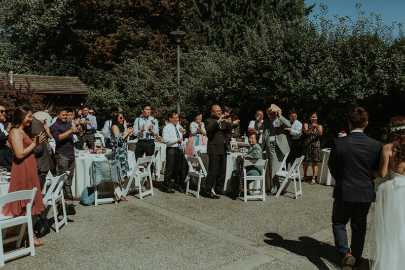 Guests applaud as bride and groom enter their PNW wedding reception.