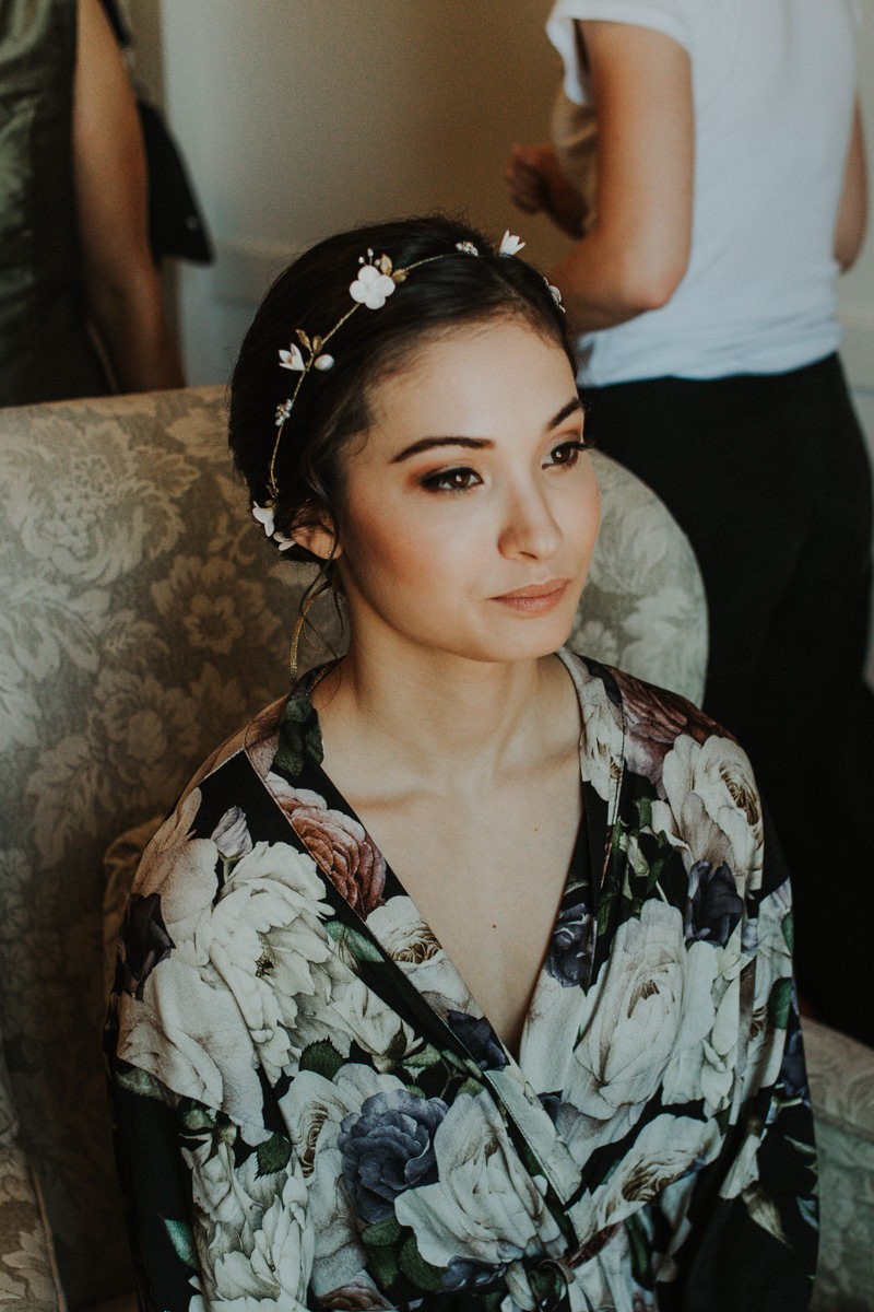 Modern bride getting ready, with floral headband and robe. 