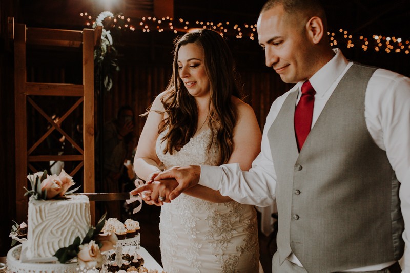 Bride and groom cutting cake at indoor wedding reception | PNW wedding + elopement photographer Meghann Prouse | www.photomegs.com