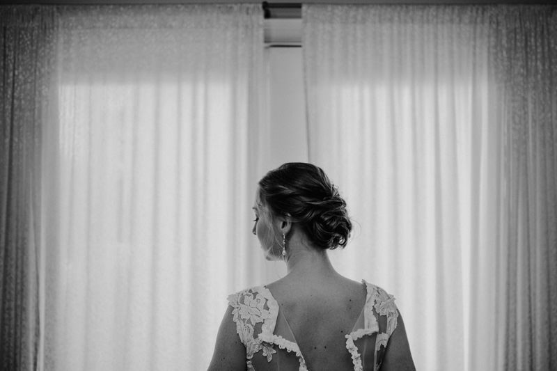 Bride getting ready in lace illusion-back dress and chignon updo at The Edgewater House in Olalla, WA | PNW wedding photographer Meghann Prouse | www.photomegs.com
