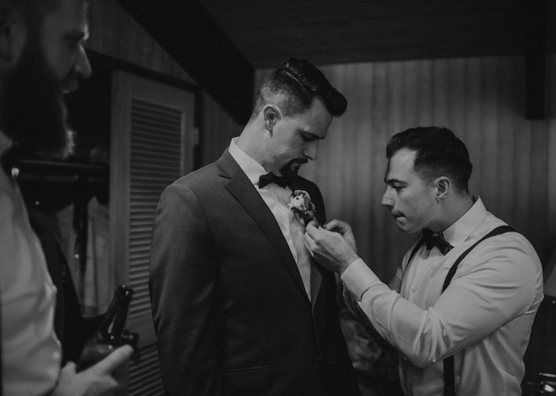 Groomsmen helping groom with boutonniere | Northwest Trek wedding day | Seattle wedding photographer
