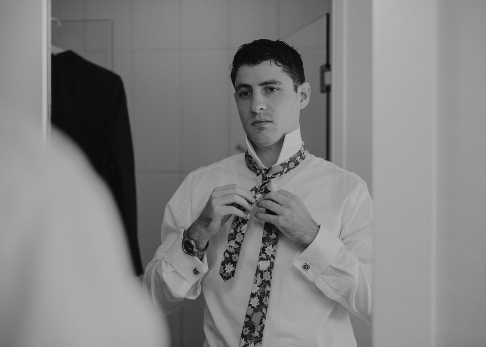 Groom getting ready with floral tie
