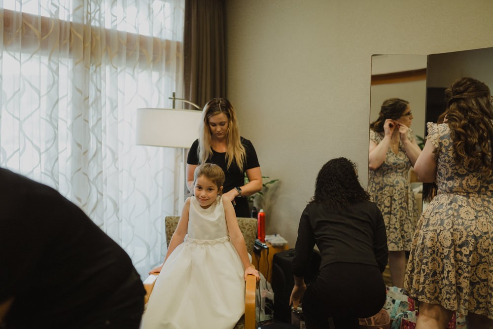 Flower girl getting ready with bride and maid of honor. 