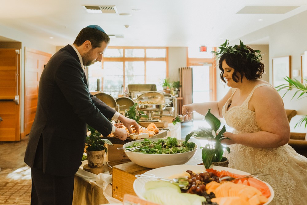 Bride and groom fill their plates with delicious foods from Willows Lodge. 