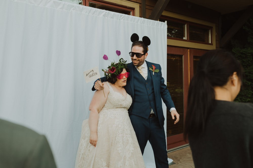 PNW bride and groom with props for photo booth. 
