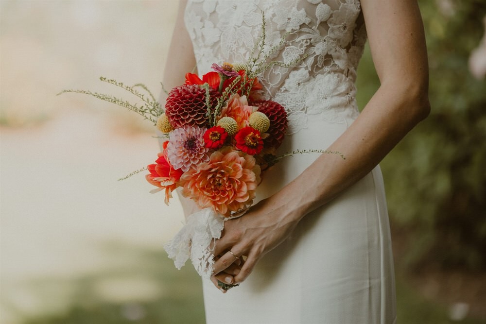Cute bright orange and red wedding bouquet, with dahlias and mums. 