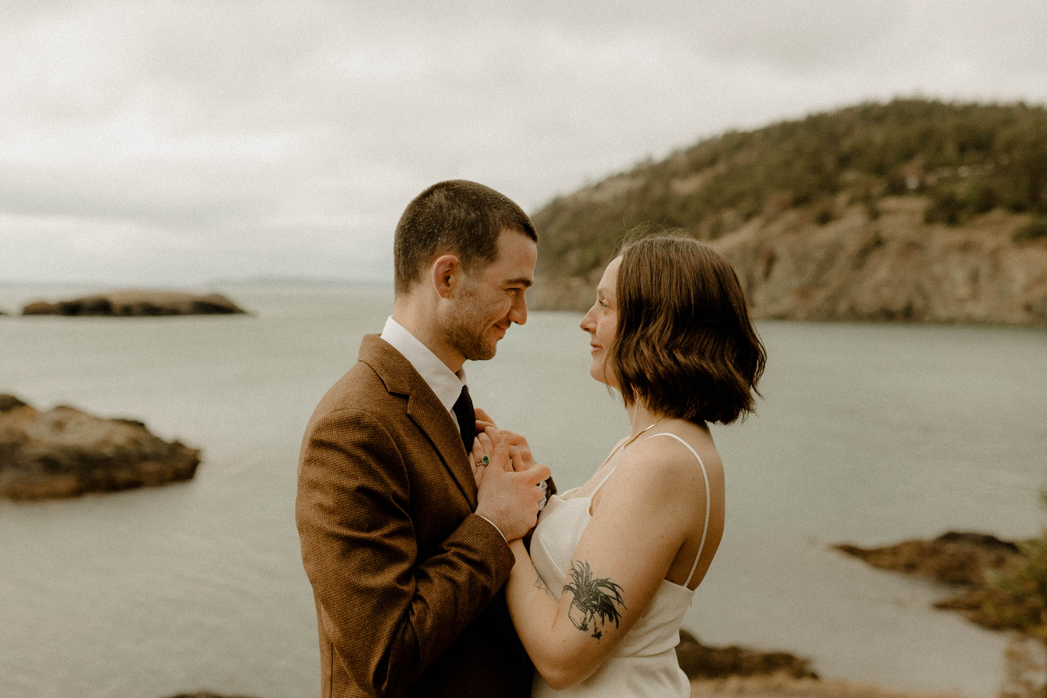 Eloping couple focused on presence and connection at Rosario Head in Washington State. 