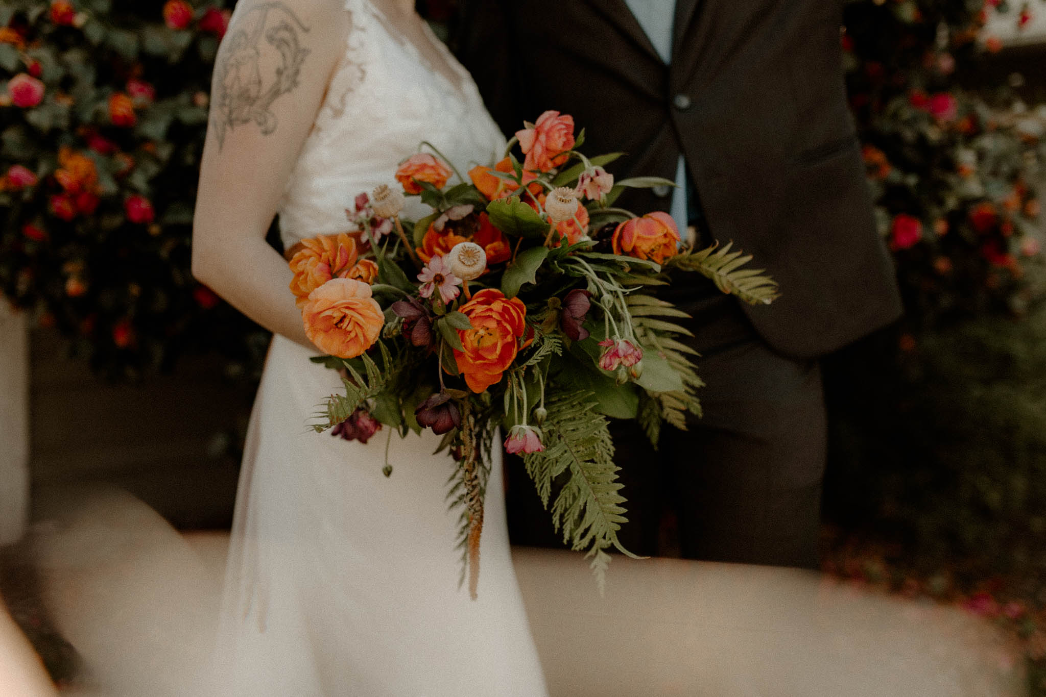 Spring cascading bridal bouquet with orange and pink flowers and ferns
