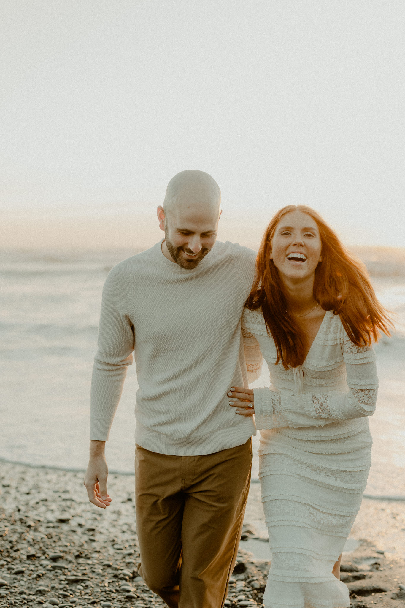 Engaged couple wearing white for a sunset beach session