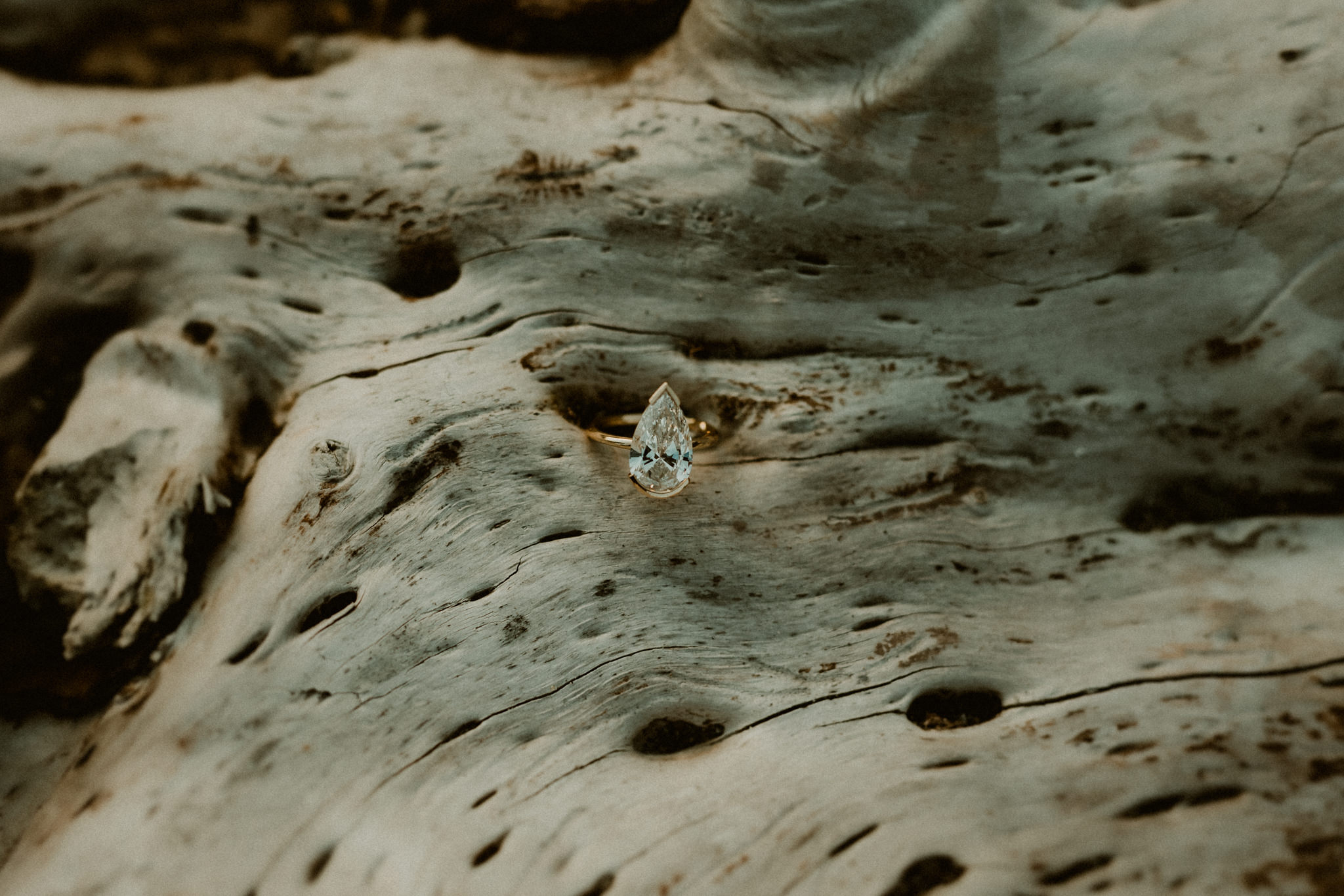 Solitaire pear shaped diamond engagement ring at the beach