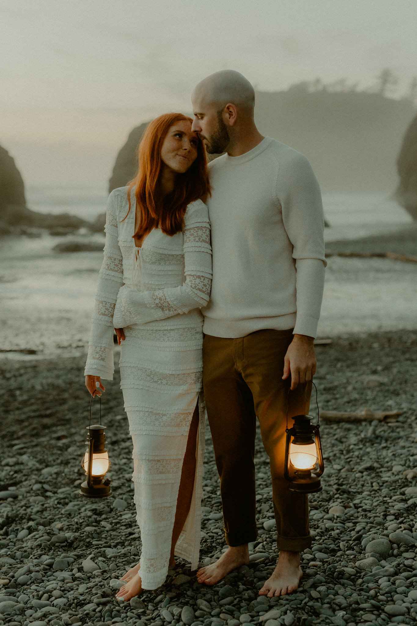 Barefoot couple at Ruby Beach at night with lanterns