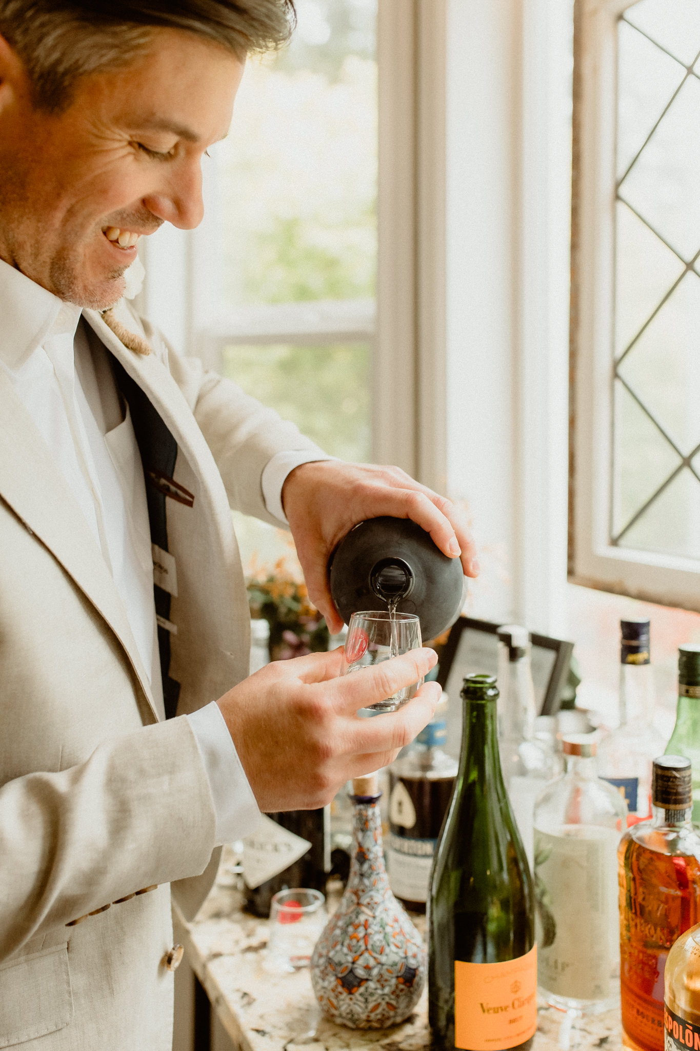 Eloping groom pouring a pre-wedding shot.